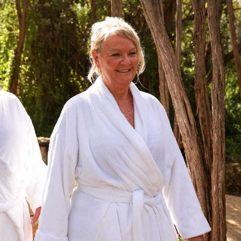 A woman wearing a white robe walking through the Spa Dreaming Centre