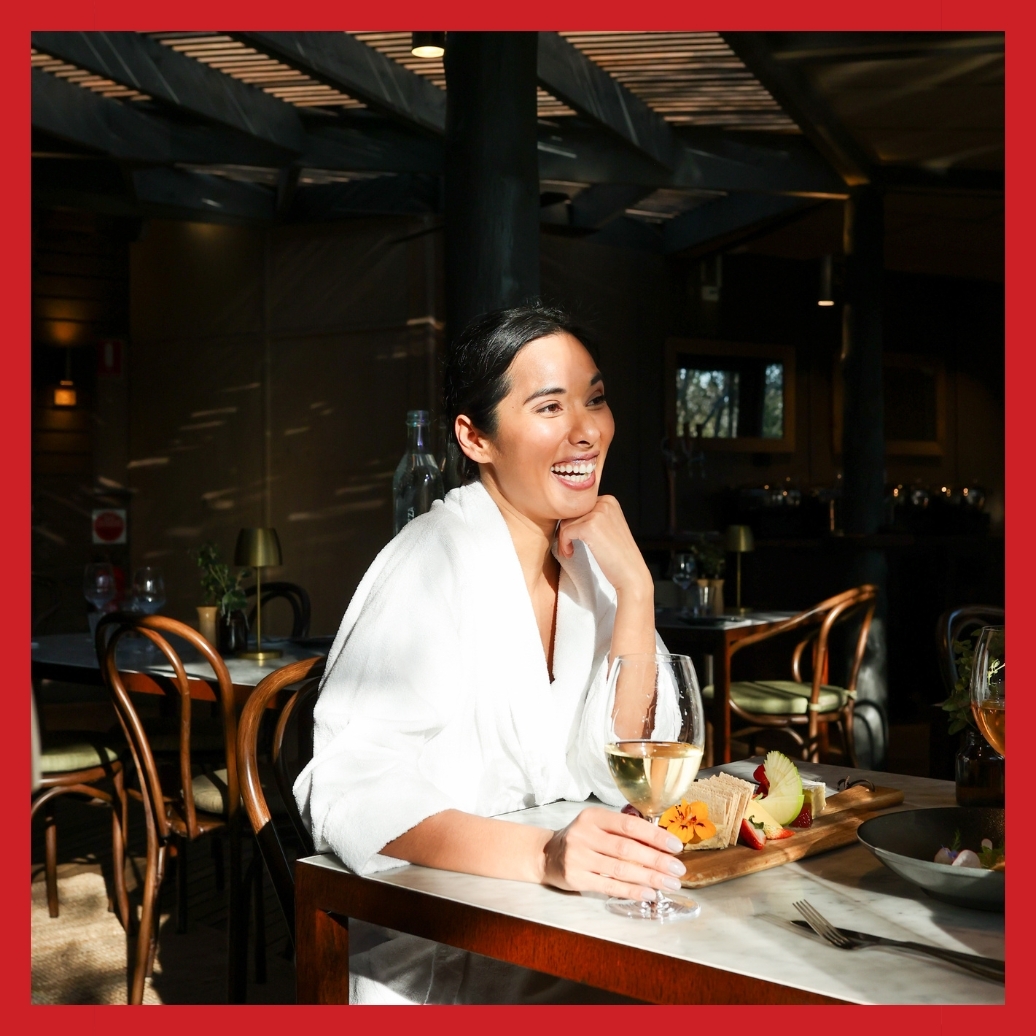 A woman smiling while dining in a robe