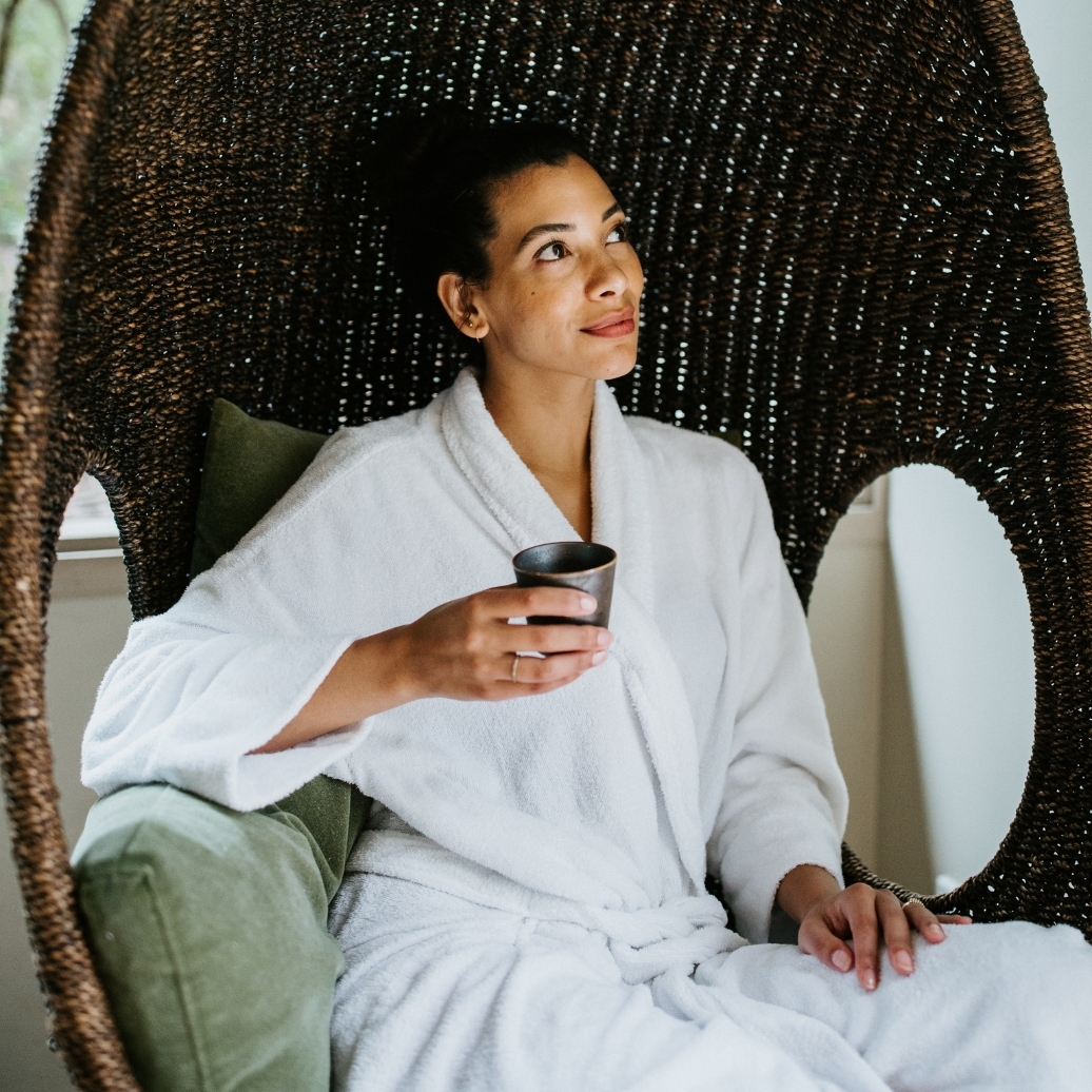 A person in a white robe drinking tea