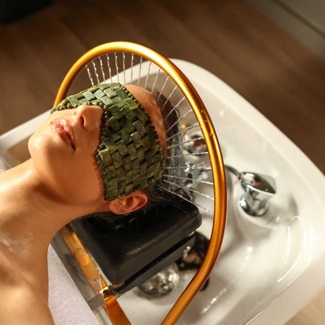 A woman wearing a crystal eye mask while enjoying a Peninsula Head Spa spa treatment