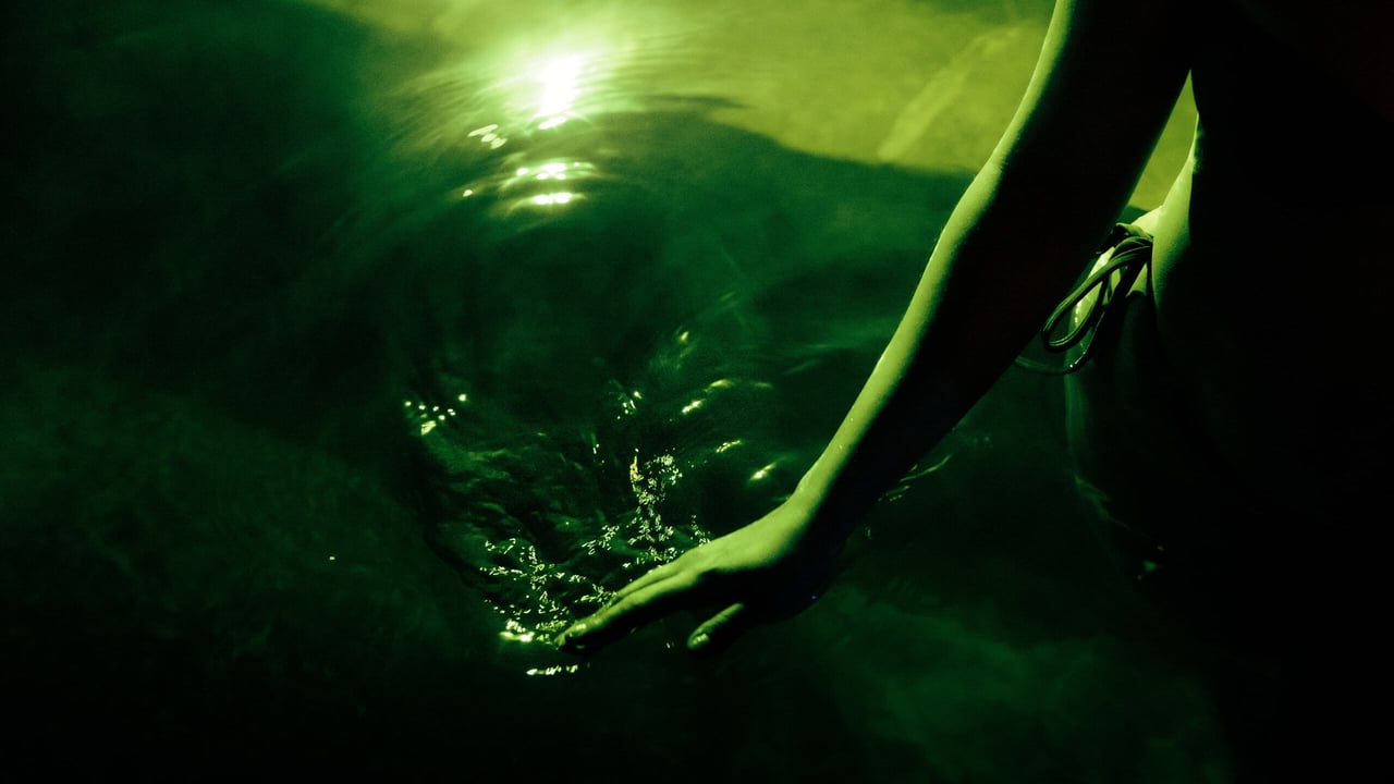 A handing running through water that has a green reflection as part of the Seek the Heat winter campaign