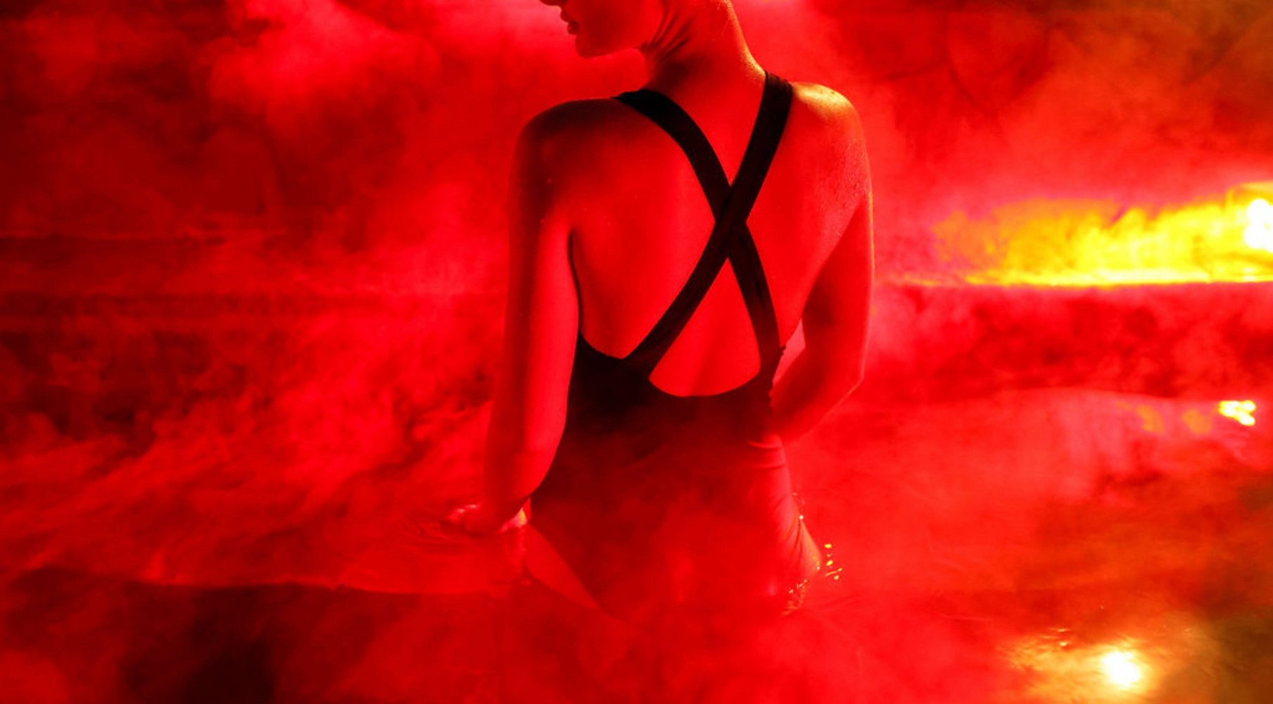 A woman bathing in hot springs that is glowing with red light