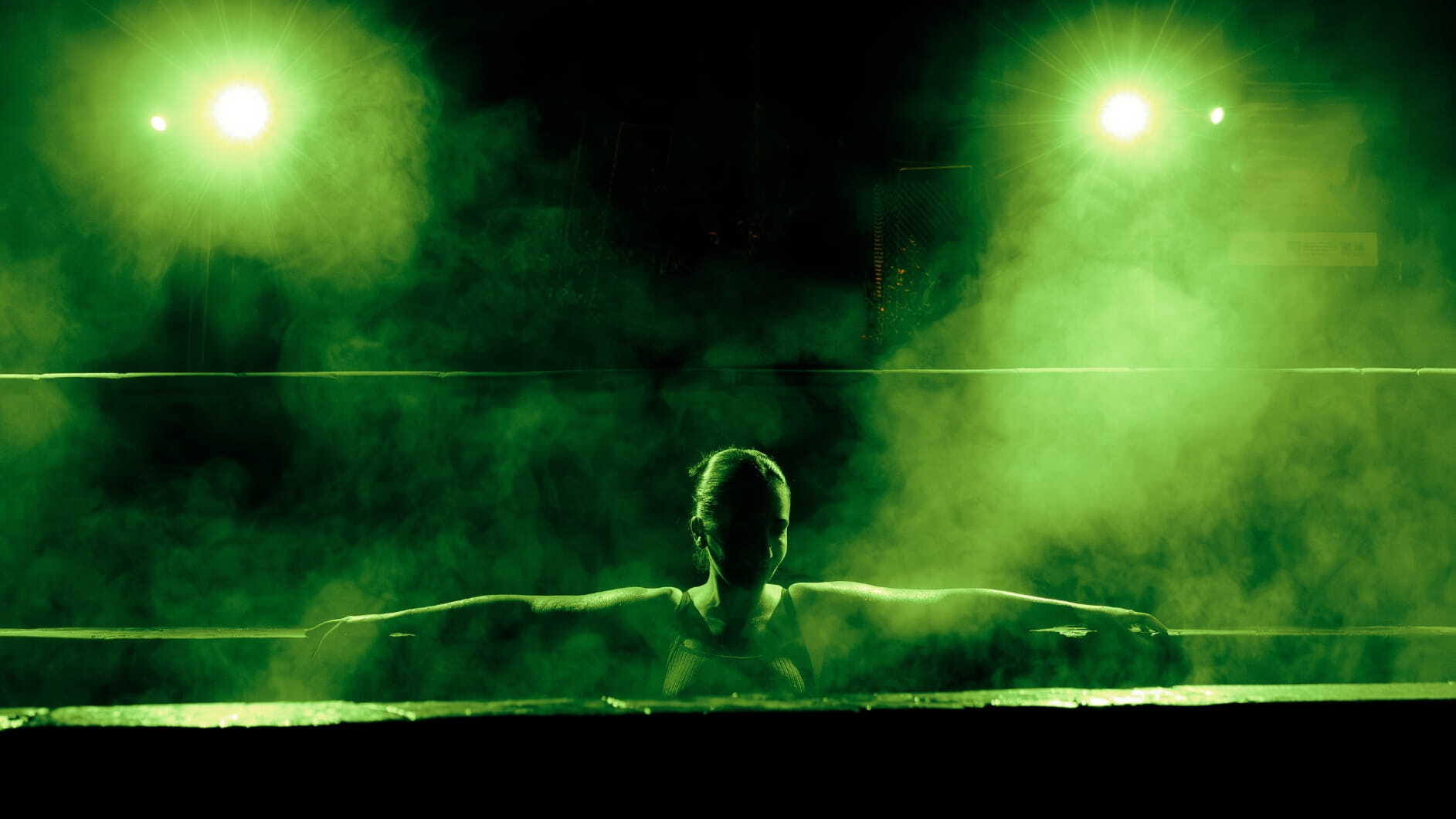 A woman in a pool that is lit up in green lights as part of the Seek the Heat campaign
