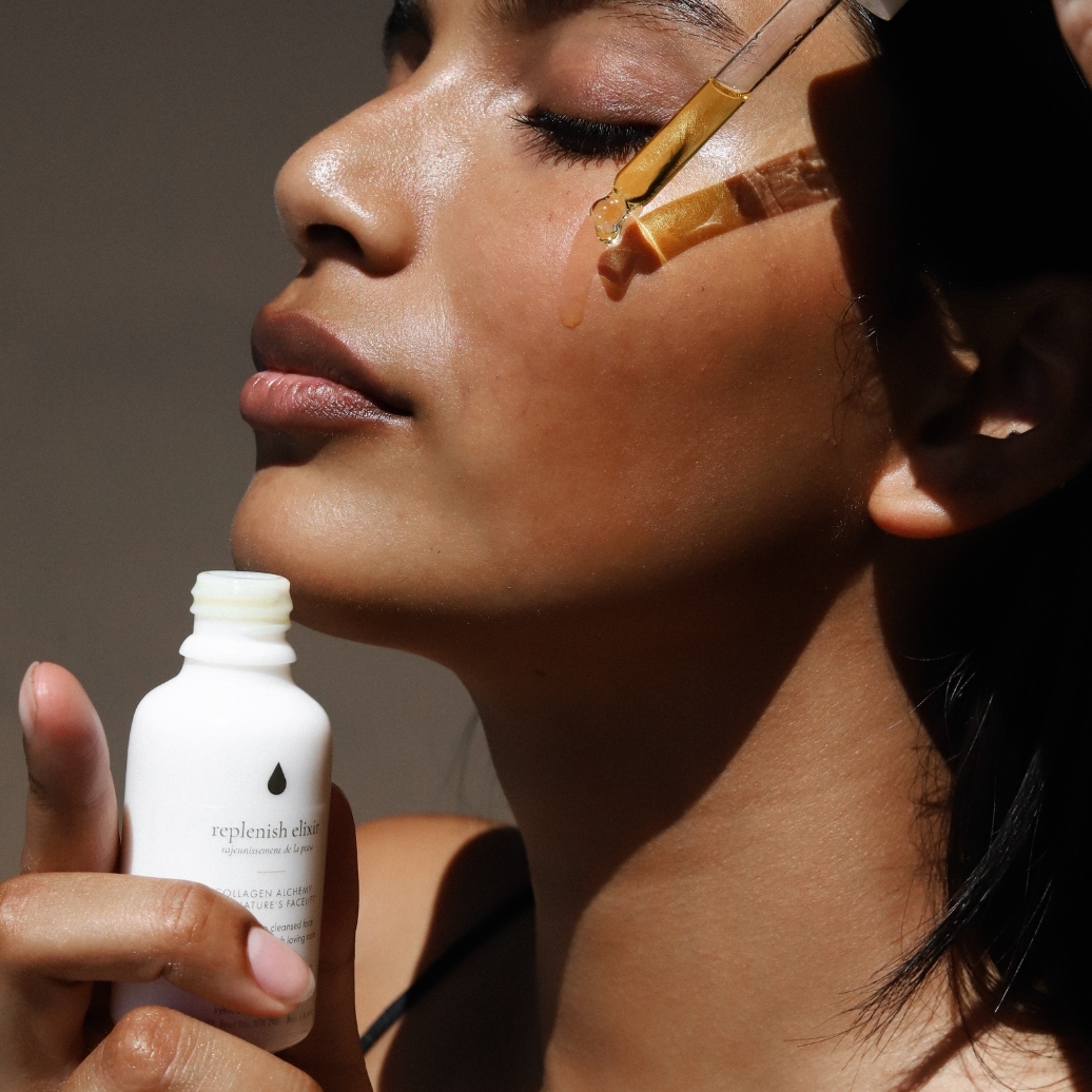 A woman dripping Synthesis Organics oil onto her face