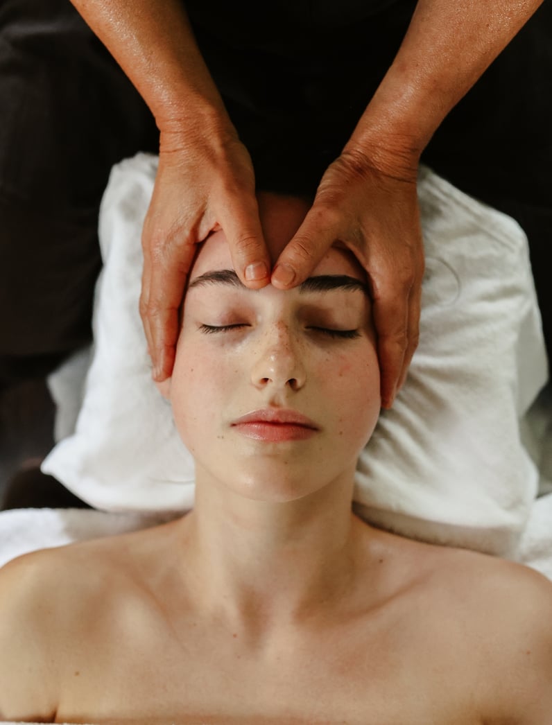 A young woman having a head massage