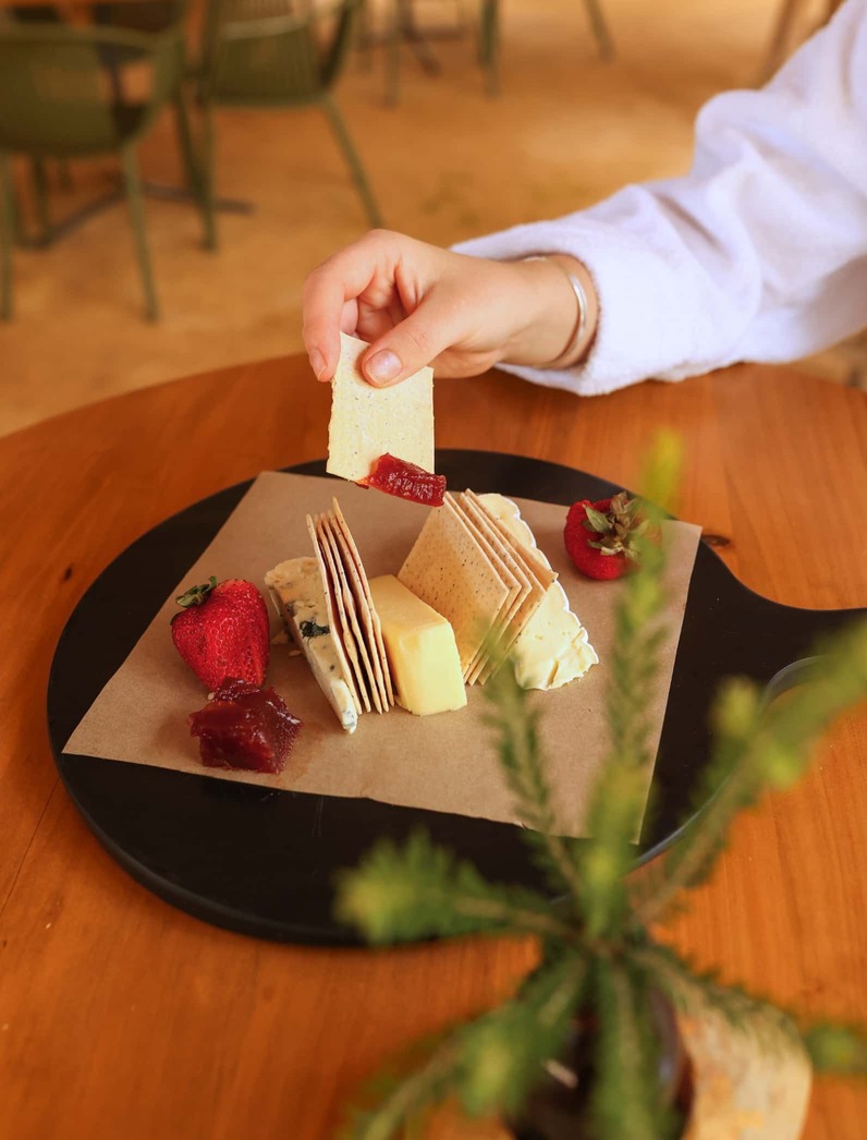 A person enjoying a cheese platter at the Bath House cafe