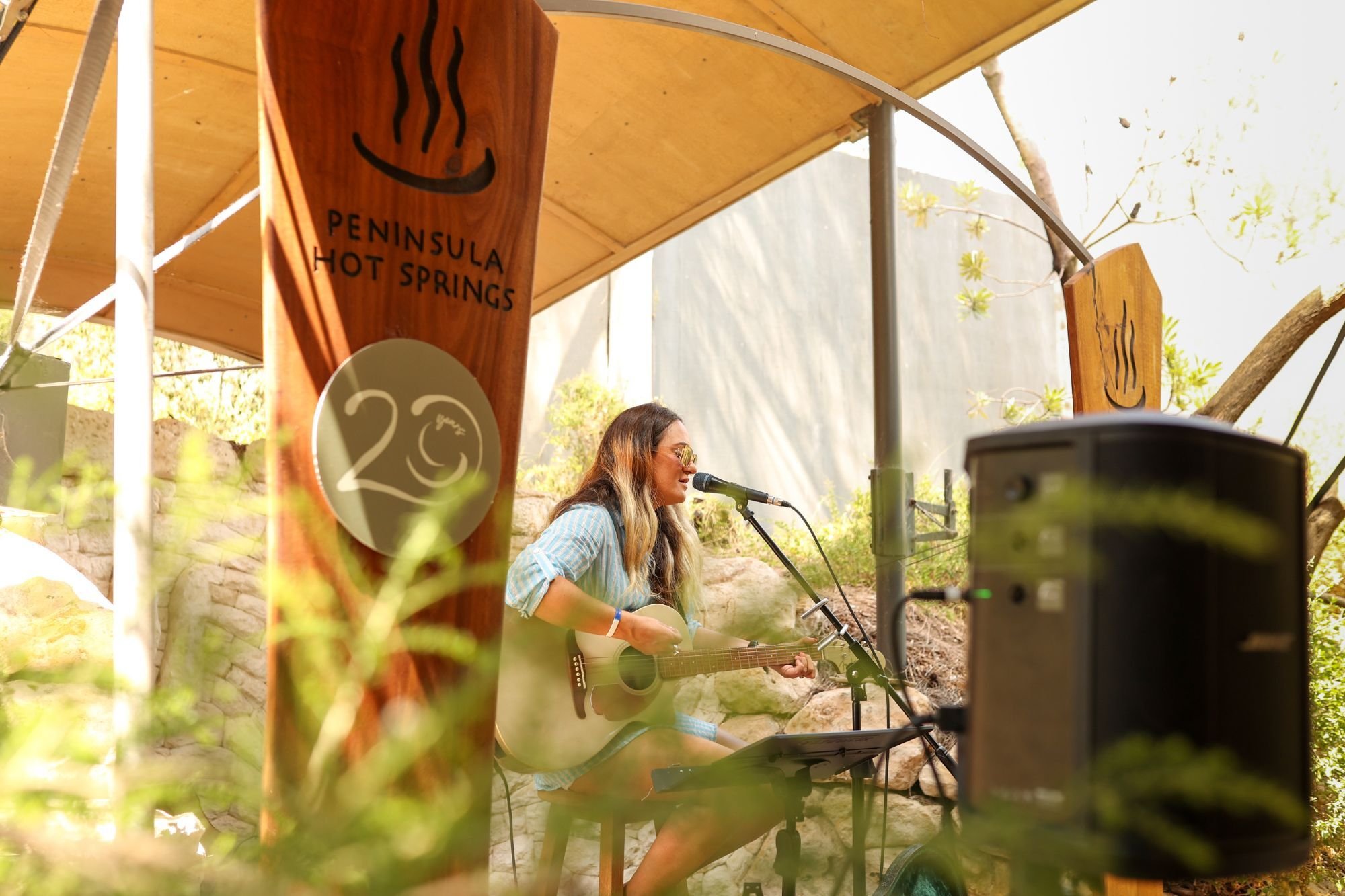 A woman playing on stage in the Bath House Cafe