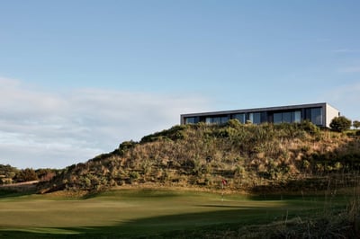 A rectangular style building on the top of a small hill