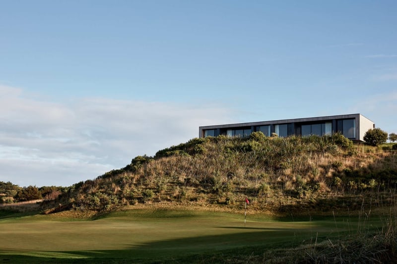 A rectangular style building on the top of a small hill