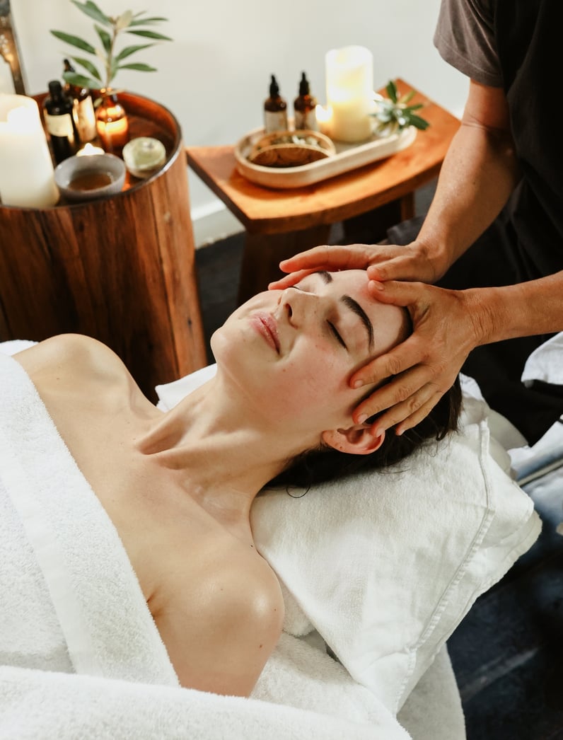 A young woman receiving a head massage