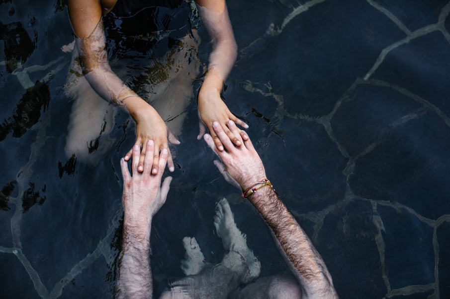 Two people holding hands in water