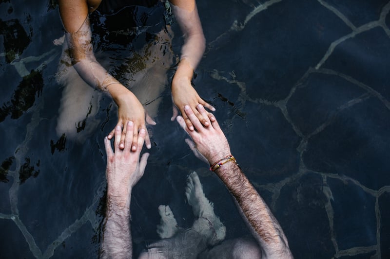 Two people holding hands in water