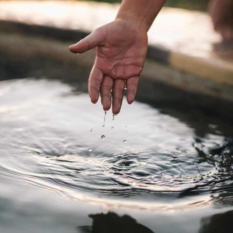 A person running their hand through water
