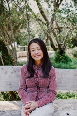 Yuki Davidson sitting on a bench surrounded by nature