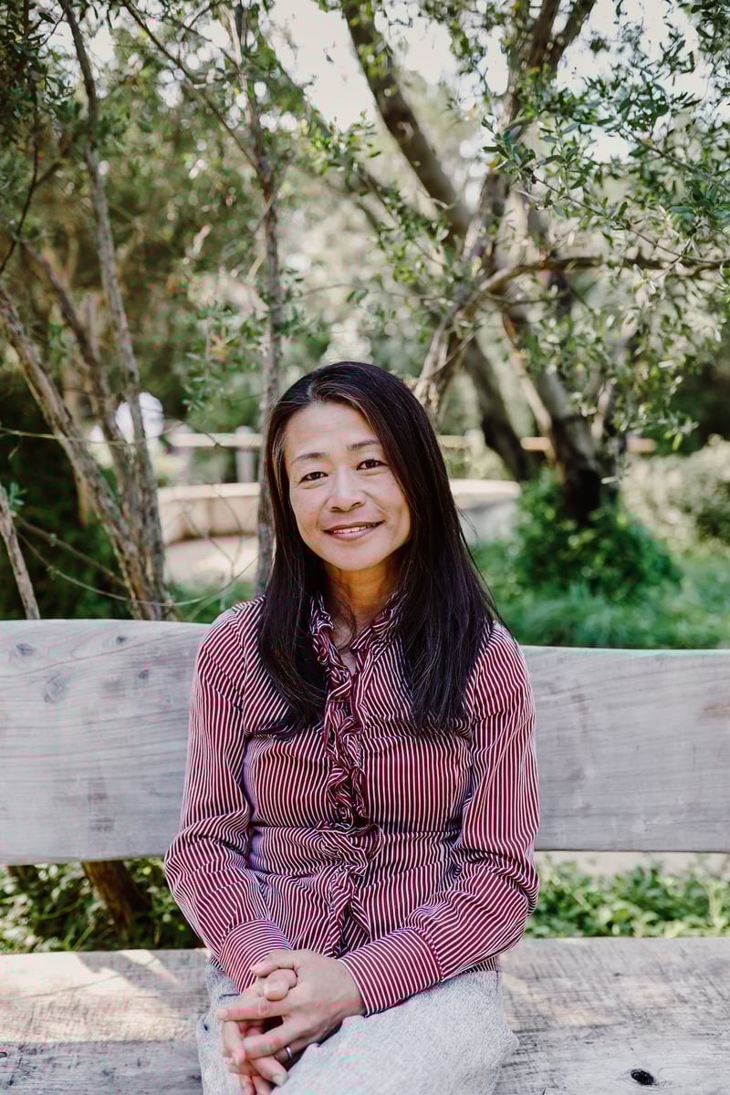 Yuki Davidson sitting on a bench surrounded by nature