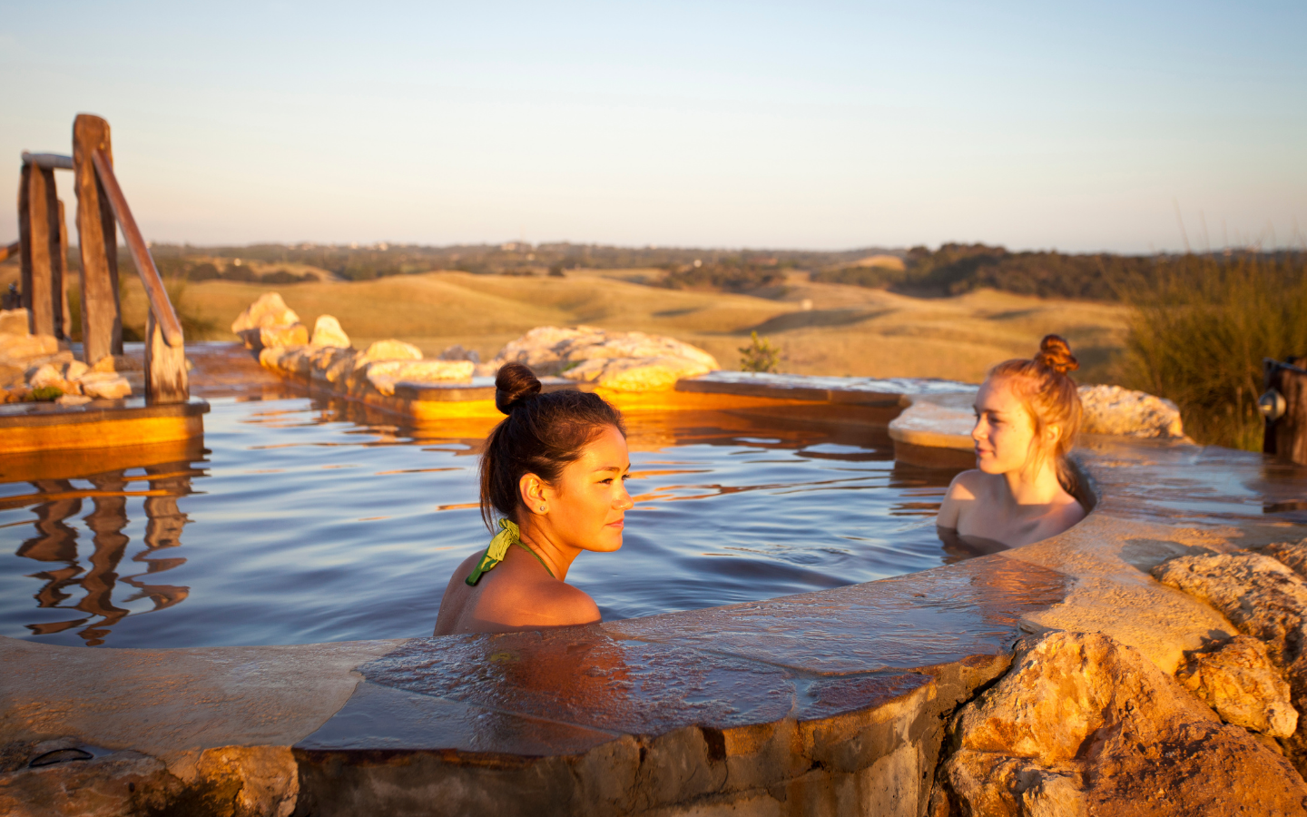 two-women-sitting-in-hilltop-pool-in-bath-house.png