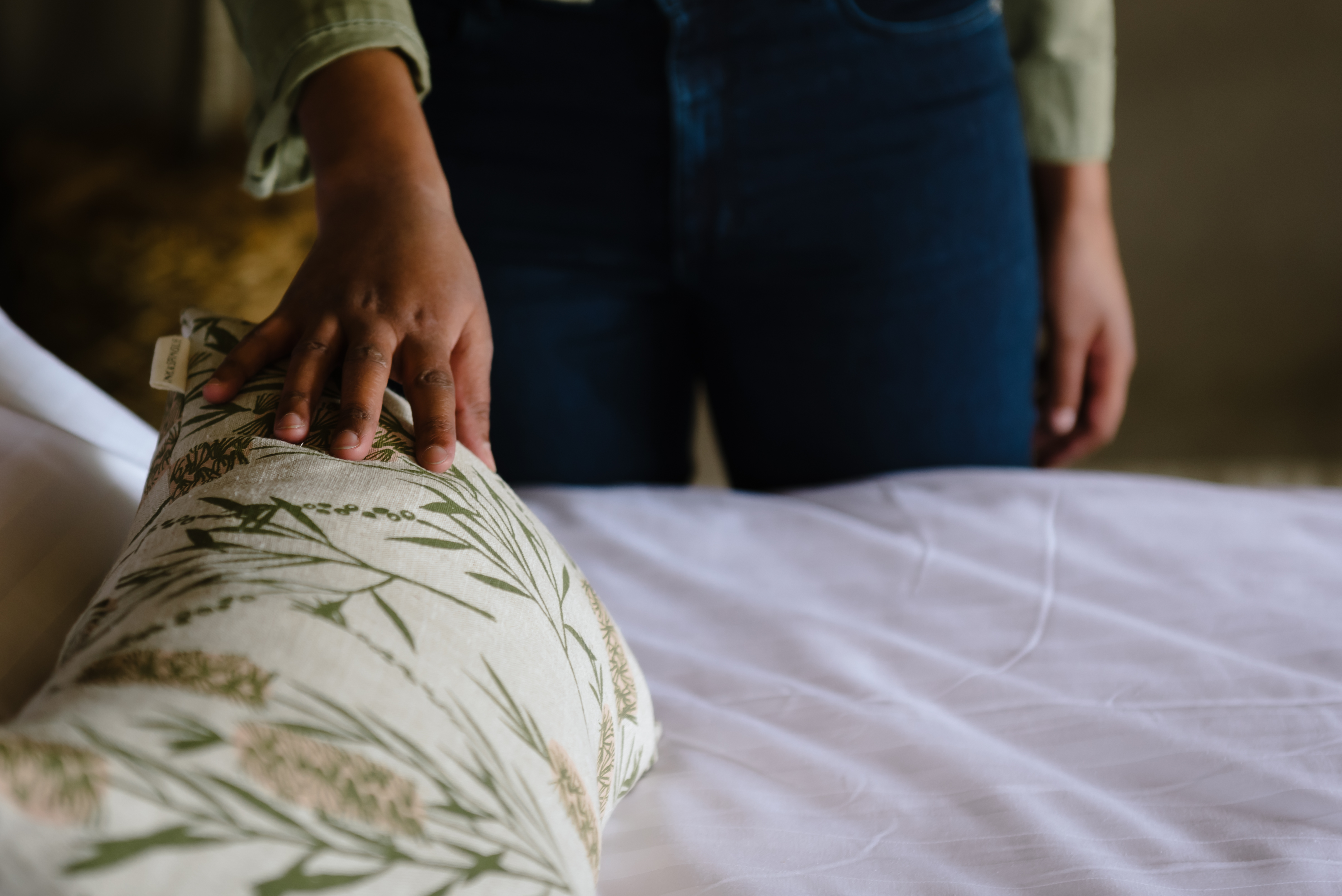 A woman's hand touching a decorative cushion