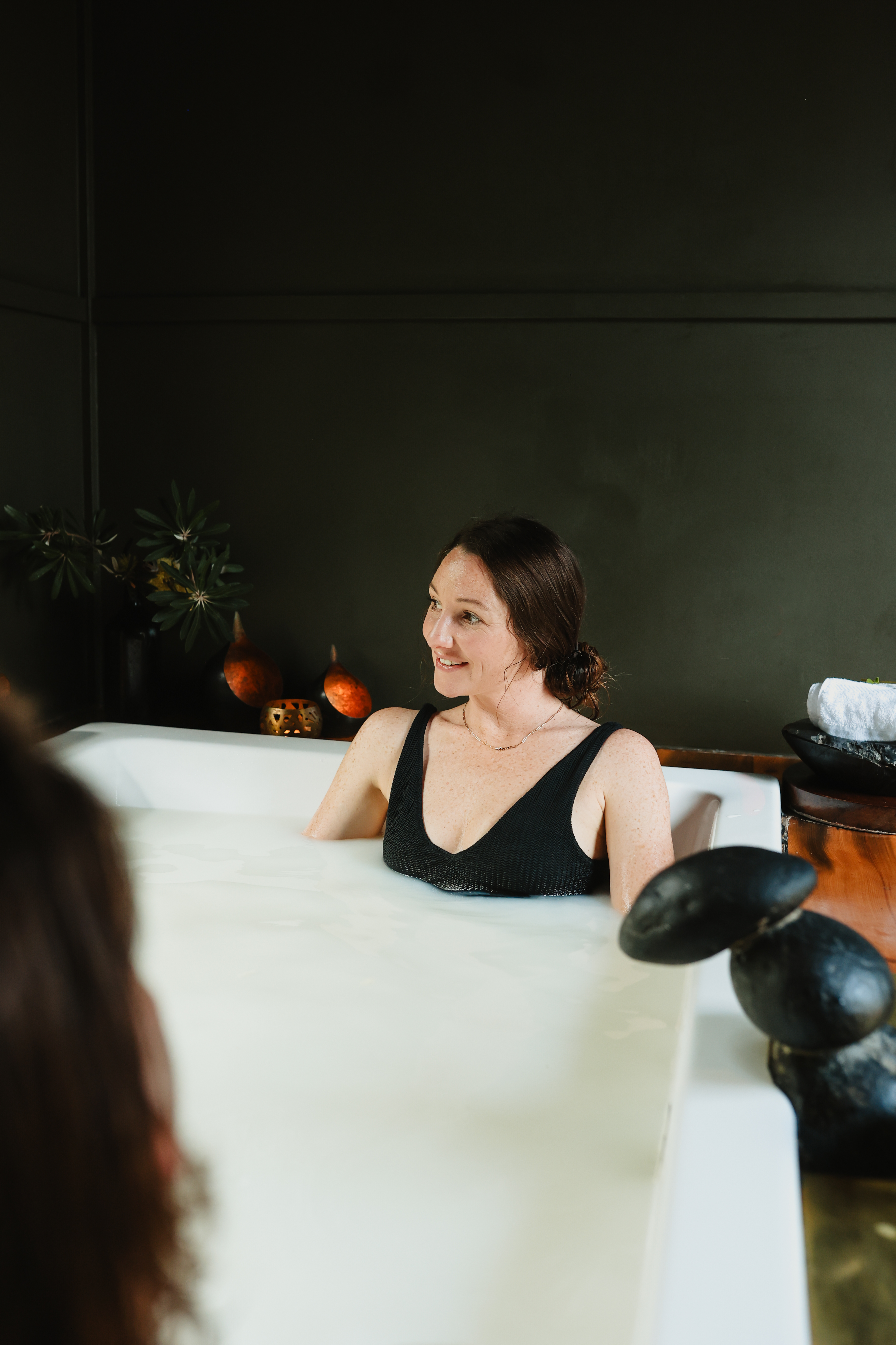 A woman bathing in a ceramic private bath